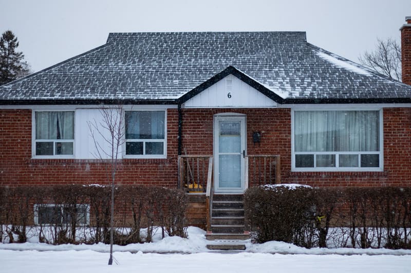 Brick bungalow in Toronto covered in snow on a winter day
